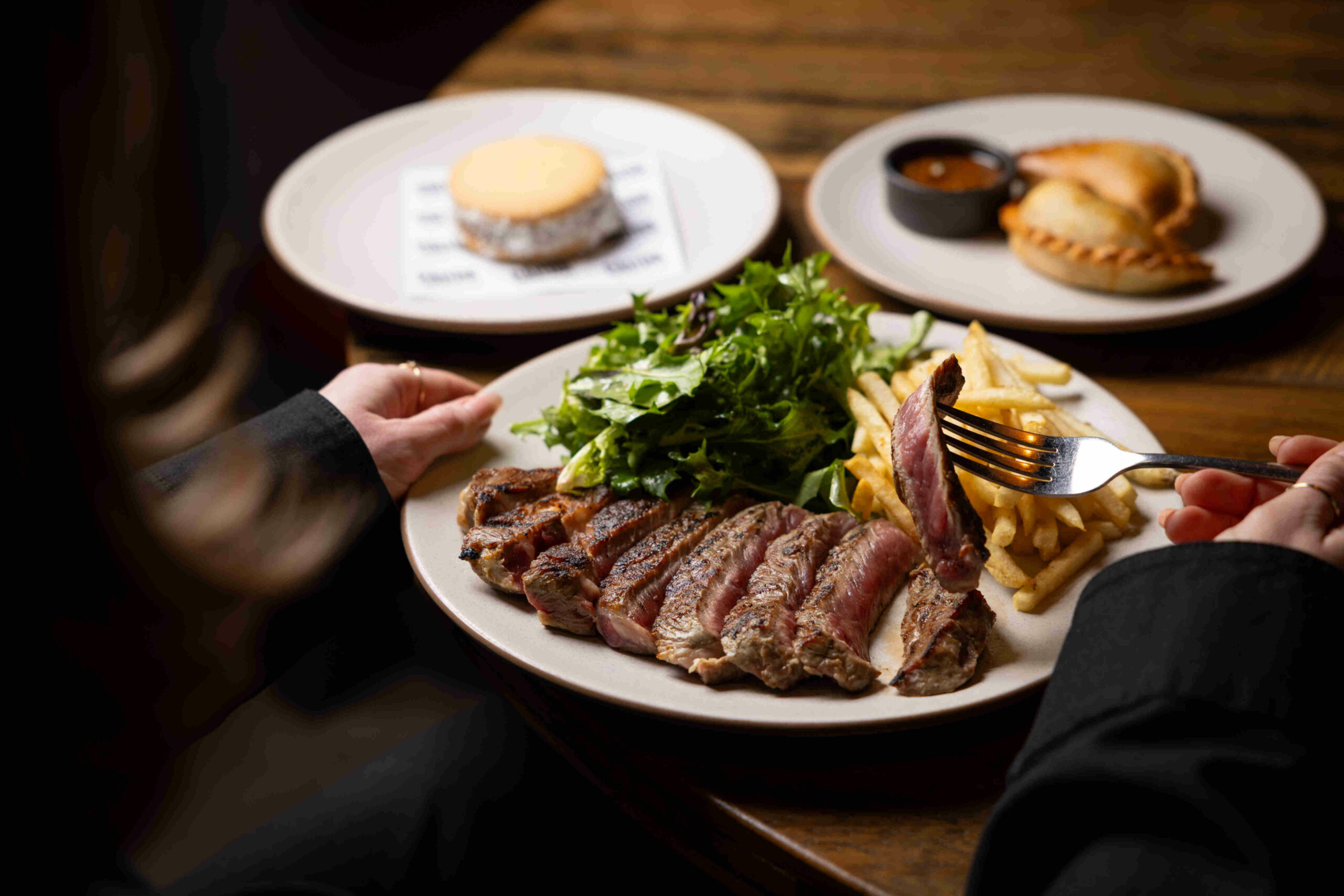 Image of a table at Calida with the Wednesday deal, a steak and empanadas with dessert special.